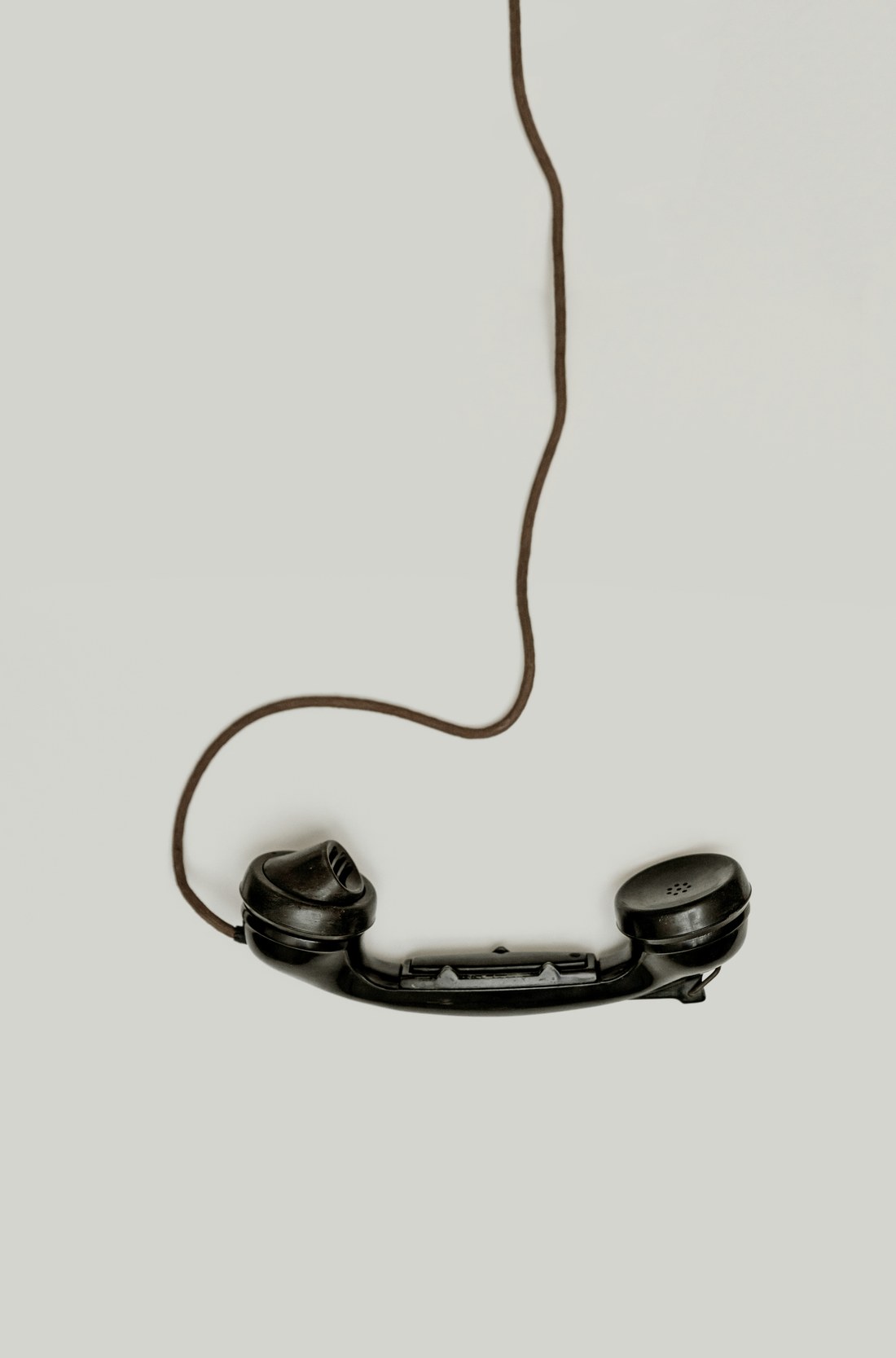 De hoorn van een oude telefoon, hangend aan zijn snoer